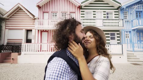 Man-kissing-woman-with-stretched-out-hand-near-buildings