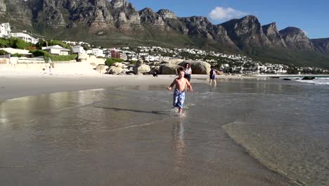 Slow-motion-of-young-boy-running-towards-the-camera-along-the-beach,South-Africa