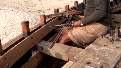 Craftsman-making-a-boat-with-primitive-tools-in-Varanasi