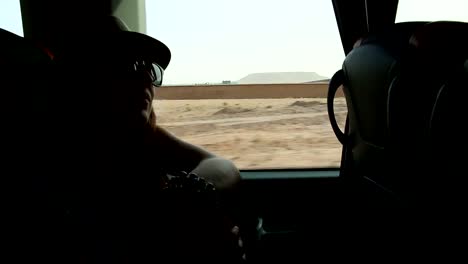 Young-woman-looking-trough-the-window-and-playing-with-hands-sitting-on-backseats-in-bus-during-road-trip