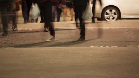 Fußgänger-überqueren-einer-Straße-in-der-Nacht,-London,-England
