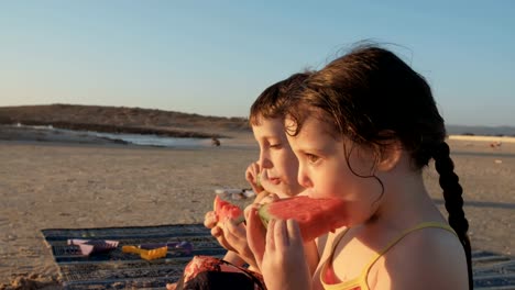 Drei-Kinder-essen-Wassermelonen-am-Strand