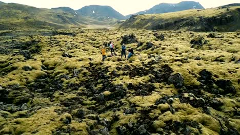 Vista-aérea-de-turistas-en-el-campo-de-lava-en-Islandia.-Copter-alejándose-de-amigos,-selfie-en-teledirigido.-Hermoso-paisaje