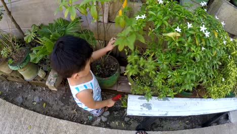 Baby-boy-learning-gardening-cutting-plant-with-toy-pliers