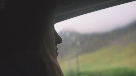 Young-woman-sitting-inside-the-car-and-looking-outside-the-window,-silhouette,-cinematic-shot