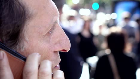 Beschäftigt-Greis-in-der-überfüllten-Straße-reden-von-Telefon-Close-up