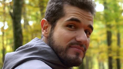 Attractive-hiking-young-man--in-the-forest--smiling-at-the-camera