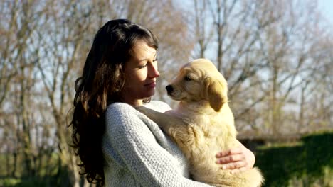 Un-abrazo-niña,-juego,-besos,-entrena-a-su-cachorro-de-perro-raza-golden-retriever-con-pedigree.-Juego-y-son-felices-y-sonrisa.