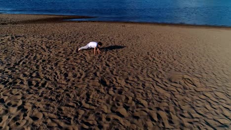 Frau-beim-Yoga-am-Sandstrand-am-Fluss-in-der-Stadt.-Schöne-Aussicht.