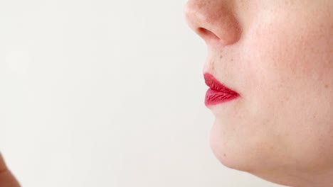 Woman-with-red-lips-eats-strawberries.-Mouth-close-up.-Side-view.