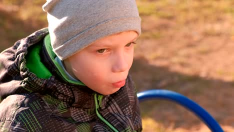 Boy-eats-waffles-sitting-on-the-bench-in-park.-Close-up-face.