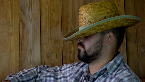 A-man-with-a-beard-in-a-straw-hat-sleeps