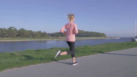 Frau-an-einem-Kanal-entlang-joggen