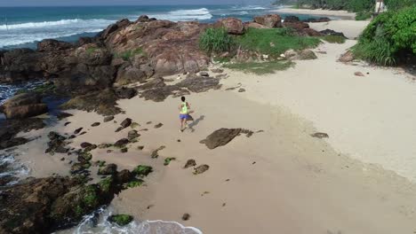 Young-woman-open-arms-on-cliff-edge-at-seaside,aerial-footage