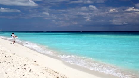 Junge-schöne-Paar-am-weißen-Sandstrand