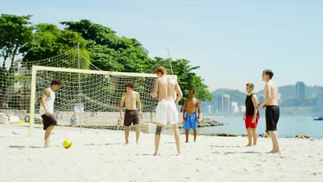 Amigos-la-práctica-las-habilidades-de-fútbol-en-la-playa-en-Brasil