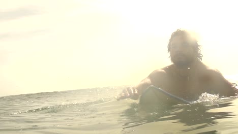 SLOW-MOTION:-Surfer-paddling-at-sunset