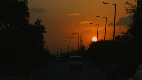 Gesperrt-Schuss-des-Verkehrs-in-Bewegung-auf-der-Straße-bei-Sonnenuntergang,-Delhi,-Indien