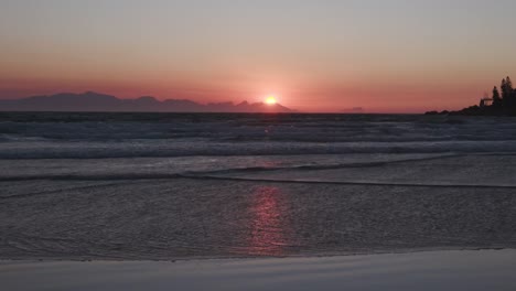 Un-amanecer-sobre-la-playa-en-Ciudad-del-Cabo,-Sudáfrica