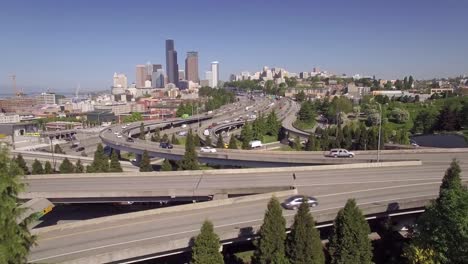 Freistil-Springen-in-Zeitlupe-fliegen-über-den-Freeway-in-die-Innenstadt-von-Seattle-bieten-einen-Wolkenkratzer-Gebäude-Skyline-auf-sonniger-Tag