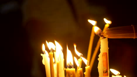 Close-up-of-prayers-hands-lighting-candles-in-the-Holy-Sepulchre-Church-in-Jerusalem