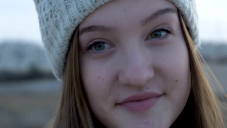 Beautiful-teenage-girl-in-a-gray-knitted-cap,-artistic-and-expressive-looking-into-a-camera,-outdoor-footage,-Israel.