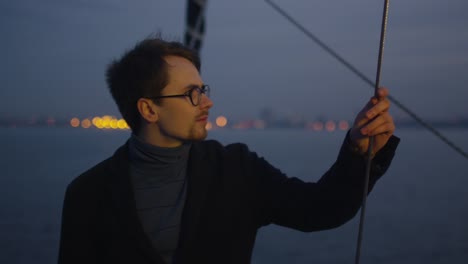 Young-man-relaxing-on-a-yacht-in-the-sea-in-evening.