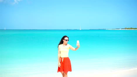 Young-woman-use-phone-taking-selfie-on-the-beacj.-Tourist-using-mobile-smartphone.