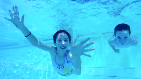 Underwater-footage-of-kids-jumping-and-diving-in-a-swimming-pool