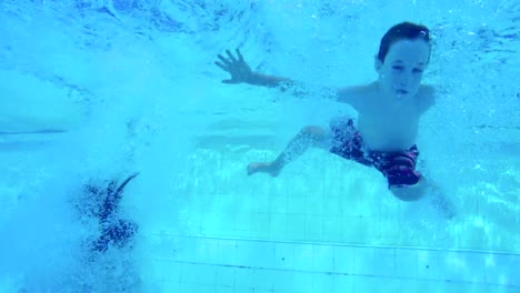 Unterwasseraufnahmen-der-Kinder-springen-und-Tauchen-im-Schwimmbad