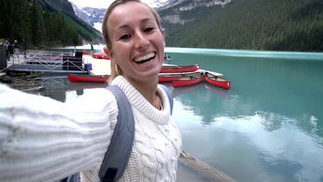 Young-woman-taking-selfie-portrait-at-Lake-Louise