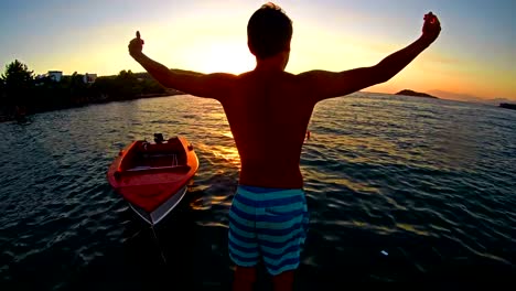 Freedom-concept,-Crane-shoot-of-successful-man-raising-hands-toward-ocean-sunset