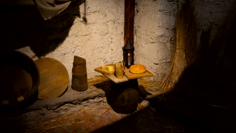 Schlechte-Zimmer-in-einem-Steinhaus-mit-Werkzeugen,-eine-Kerze-und-Essen