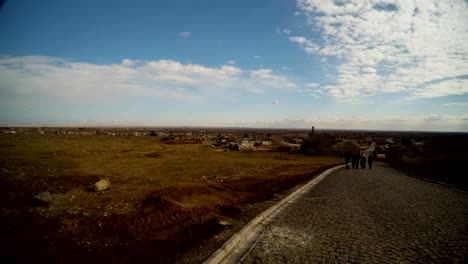 un-grupo-de-personas-en-la-distancia-en-la-carretera-en-las-afueras-de-una-antigua-ciudad-árabe-en-el-sur-de-Turquía