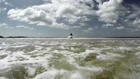 4K-Footage-of-young-man-running-into-the-ocean-waves-with-old-surfboard