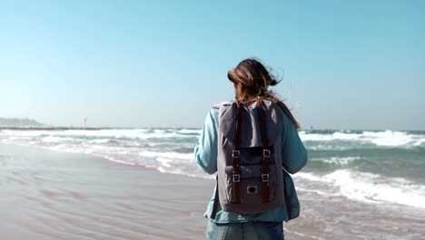 Girl-walks-on-summer-sea-beach-thinking-about-life.-Freedom-and-retreat-concept.-Wind-blowing-in-hair.-Amazing-sky.-4K