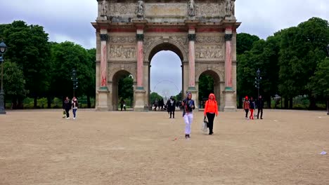 Tourists-at-Paris-landmarks-at-day,-zoom-to-ferris-wheel-over-Arc-de-Triomphe-du-Carrousel-at-entrance-of-Tuileries-Palace