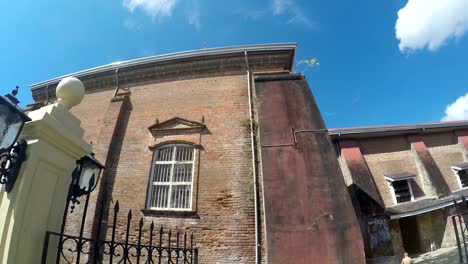 Colonial-16th-century-Spanish-built-of-Saint-Paul-the-First-Hermit-Cathedral-also-known-as-San-Pablo-Cathedral,-showing-her-surrounding-iron-fence-at-the-east-side-nave-brick-walls.-tracking-shot