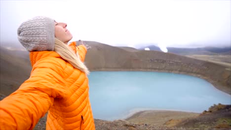 Slow-motion-Young-woman-arms-outstretched-at-spectacular-crater-lake-in-Iceland