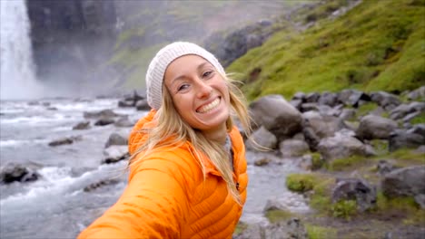 Follow-me-to-the-waterfall-young-woman-waving-at-boyfriend,-girlfriend-leading-man-to-falls-in-Iceland-People-travel-concept--Slow-motion