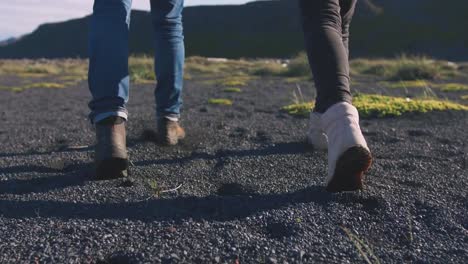 Cerrar-tiro-de-joven-amante-pareja-corriendo-en-la-playa-en-Islandia-durante-la-puesta-de-sol,-cámara-lenta