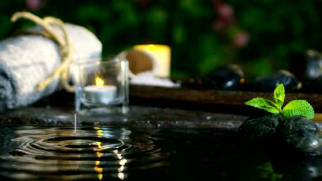 Dispara-a-agua-hermosa-y-la-composición-de-spa-y-wellness-de-velas-en-extremo-lento-motion.concept-de-relax-y-meditation.water