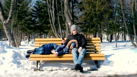 Mann-und-Frau-ausruhen-zusammen-im-Winter-City-Park-auf-einer-Bank.