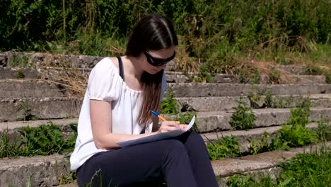 Junge-Mädchen,-das-ihre-Aufgaben-und-Hausaufgaben-sitzen-im-Park.-College-Student.