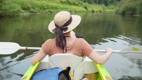 Chica-joven-canoa-en-un-lago-hermoso-y-relajarse-bajo-el-sol