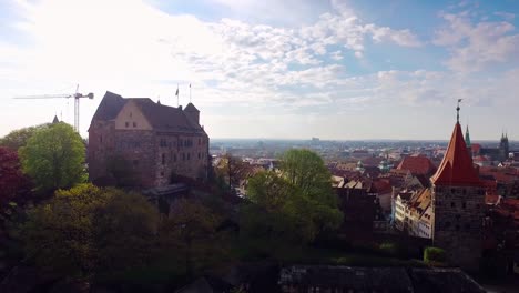 Aerial-steigende-Stadt-mit-einer-Burg-im-Vordergrund-bei-schönen-Sonnenaufgang