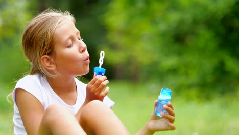 Little-girl-playing-with-soap-bubbles-outdoor.-Slow-motion.