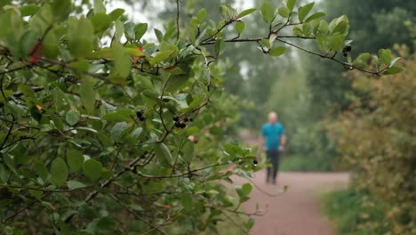 Mature-caucasian-man-in-blue-t-shirt-running-outdoor.-Jogging-on-fresh-air.