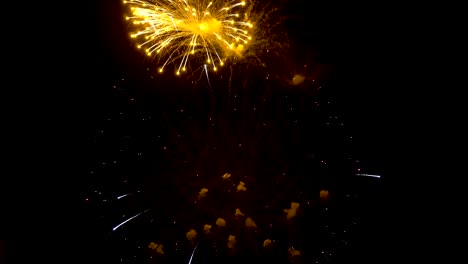 Espectáculo-de-fuegos-artificiales.-Hermosos-destellos-de-amarillos,-rojos-y-lilas-en-el-cielo-nocturno-sobre-un-fondo-negro.