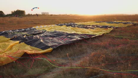 Paracaídas-en-el-suelo-de-los-rayos-del-atardecer-del-sol-en-el-campo-de-aviación